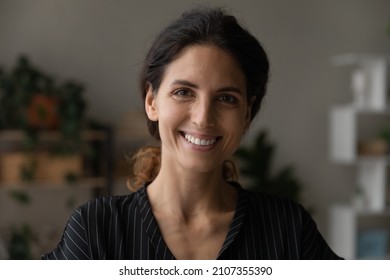 Head Shot Portrait Of Pleasant Attractive Millennial Caucasian Hispanic Latina Woman Renter Posing In Modern Renovated Apartment. Profile Picture Of Happy Young Female Homeowner In New Dwelling.