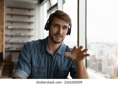 Head Shot Portrait Of Positive Confident Millennial Man In Headphones Working From Home, Making Video Call, Looking, Talking At Webcam. Business Teacher, Coach Giving Virtual Webinar. Screen View