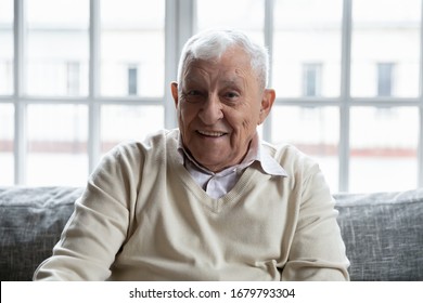 Head Shot Portrait Positive Old Man Feels Healthy Sitting On Couch Looking At Camera. Healthcare And Health Exam Check Up For Senior Clinic Advertisement, Care About Old People Baby Boomer Generation