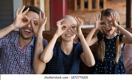 Head Shot Portrait Sick Hairless Woman Cancer Patient With Family Making Funny Faces, Looking At Camera, Unhealthy Mother And Father With Adorable Child Posing For Photo, Having Fun Together