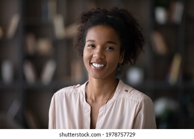 Head shot portrait of sincere smiling attractive millennial generation mixed race african woman looking at camera, holding video call online zoom meeting, professional blogger shooting video. - Powered by Shutterstock