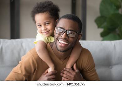 Head Shot Portrait Of Smiling African American Father Piggyback Little Son, Attractive Black Man In Glasses With Toddler Boy On Back Looking At Camera, Adorable Child Embracing Dad, Making Video Call