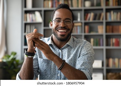 Head shot portrait smiling African American man wearing glasses making video call, looking at camera, confident positive young coach leading remote lesson, businessman participating online conference