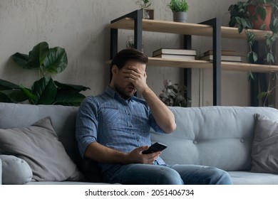 Head Shot Portrait Smiling Bearded Man Holding Smartphone, Sitting On Couch, Happy Young Male Looking At Camera, Spending Leisure Time With Mobile Device At Home, Chatting Or Shopping Online