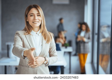 Head shot portrait smiling  businesswoman offering handshake, standing with extended hand in modern office, friendly hr manager or team leader greeting or welcoming new worker - Powered by Shutterstock