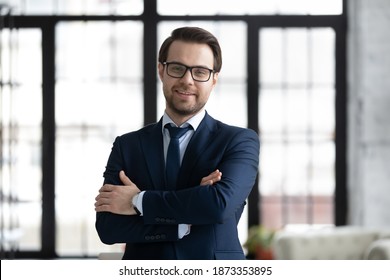 Head Shot Portrait Smiling Confident Businessman Wearing Suit And Glasses Looking At Camera, Profile Picture Successful Executive Company Owner With Arms Crossed Standing Posing In Modern Office