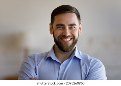 Head shot portrait of smiling confident young bearded man, posing indoors, real estate ownership. Joyful millennial guy showing sincere smile, feeling satisfied with professional dental procedures.