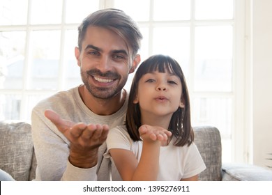 Head Shot Portrait Of Smiling Father And Daughter Making Video Call Together, Sending Blow Kiss, Happy Dad And Cute Child Looking At Camera, Saying Hello Or Goodbye, Talking At Webcam At Home