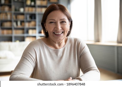 Head shot portrait smiling mature woman making video call, grandmother chatting with relatives, using webcam, happy middle aged blogger recording vlog, teacher holding online lesson, distance lecture - Shutterstock ID 1896407848