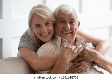 Head Shot Portrait Smiling Older Wife And Husband Hugging, Looking At Camera, Family Posing For Photo Together At Home, Happy Mature Father With Caring Adult Middle-aged Daughter Embracing