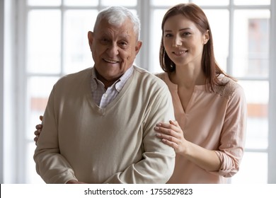 Head Shot Portrait Smiling Older Father With Grownup Daughter Looking At Camera, Happy Mature Man And Young Beautiful Woman Standing At Home, Posing For Photo Together, Two Generations Concept