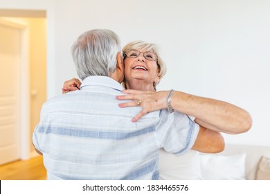 Head Shot Portrait Smiling Older Woman Dancing With Man, Happy Mature Wife And Husband Hugging, Standing In Living Room, Senior Family Enjoying Tender Moment, Celebrating Anniversary