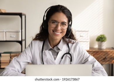 Head Shot Portrait Smiling Professional Female Doctor Physician Wearing Headphones And Uniform Working Online, Consulting Patient, Using Laptop, Virtual Meeting, Telemedicine Service Concept