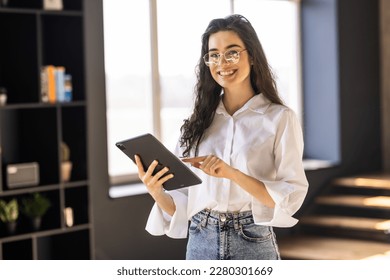 Retrato de la cabeza sonriente mujer sujetando una tableta de computadora moderna en las manos