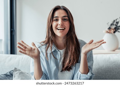 Head shot portrait smiling woman making video call to friends or relatives, using webcam, sitting on couch at home, happy young female blogger recording vlog, looking at camera, chatting online - Powered by Shutterstock