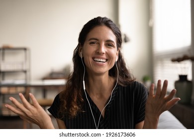 Head shot portrait smiling young woman wearing earphones speaking at camera, teacher leading webinar, enjoying pleasant conversation, making video call, blogger recording vlog for social network