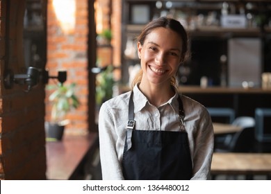 Head shot portrait successful mixed race businesswoman happy restaurant or cafeteria owner looking at camera, woman wearing apron smiling welcoming guests having prosperous catering business concept