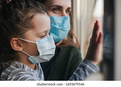 Head Shot Portrait Unhealthy Young Caucasian Family Wearing Medical Face Mask Sitting In Windowsill At Home, Concept Of Coronavirus Or COVID-19 Pandemic Disease Symptoms, Flu And Viral Infections