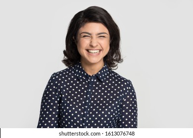 Head shot portrait young indian ethnicity overjoyed woman laughing, having fun, feeling joyful excited, listening to joke or good news, isolated on grey studio background. Positive emotions concept.