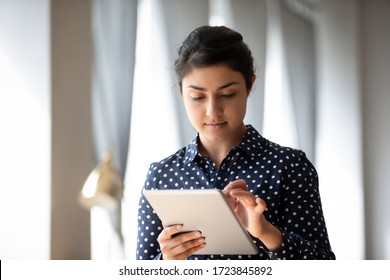 Head Shot Pretty Focused Indian Millennial Woman Using Digital Computer Tablet, Chatting With Friends In Social Network. Motivated Young Hindu Female Professional Architect Drawing Sketch Design.