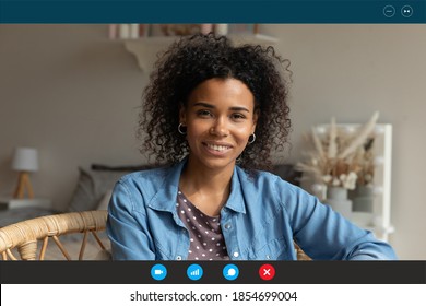 Head shot relaxed young african american attractive happy woman looking at web camera, enjoying nice pleasant weekend leisure remote talk with friends, using video call computer application at home.