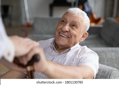 Head shot smiling old male pensioner involved in rehabilitation procedure with caring young physiotherapist. Happy 80s retired man with walking disability feeling thankful for professional help.