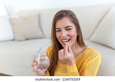 Head Shot Smiling Young Woman Holding Pill And Glass Of Fresh Pure Water. Healthy Millennial Lady Taking Antioxidant Medicine Vitamins, Beauty Supplements For Hair Skin Nails, Healthcare Concept.