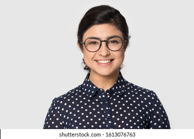 Head Shot Studio Portrait Millennial Indial Pretty Smiling Girl Wearing Eyeglasses, Looking At Camera. Confident Student Intern, Young Company Worker, Female Professional Isolated On Grey Background.