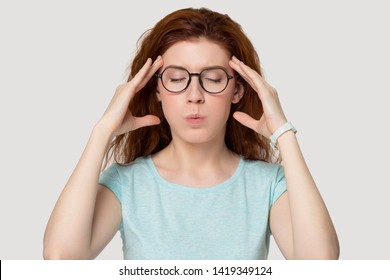 Head shot studio portrait red-headed worried woman in glasses closed eyes touch temples makes no stress fear relief exercise, breathing reduce anxiety, self control, suffers from panic attack concept