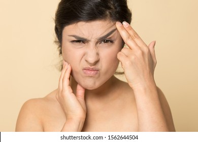 Head Shot Unhappy Stressed Indian Woman Touching Face, Worried About Wrinkle Or Acne, Looking At Camera, Facial Cosmetology, Treatment, Skincare Concept, Isolated On Brown Studio Background