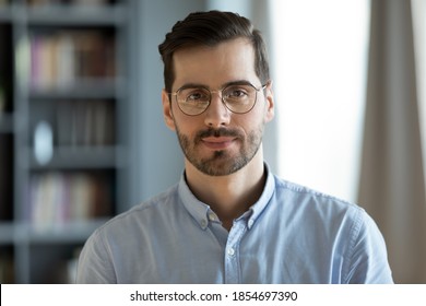 Head shot young attractive businessman in glasses standing in modern office pose for camera. Videoconference call profile picture handsome entrepreneur portrait, professional occupation person concept - Shutterstock ID 1854697390