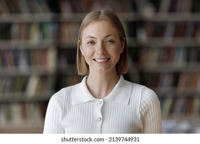 Head shot young beautiful teenager girl smile looking at camera. Blond 18s student posing in university library, concept of higher education, high school excellent pupil portrait, studentship concept - Shutterstock ID 2139744931