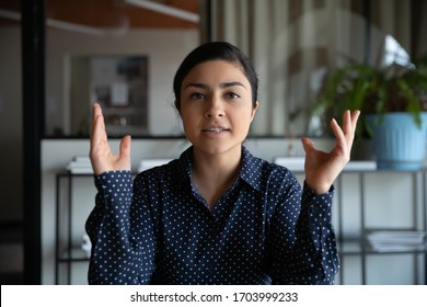 Head shot of young Indian female employee talk on video call with colleague or business partner, ethnic businesswoman speak have WebCam conference, consult client online on laptop at home - Shutterstock ID 1703999233