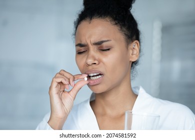 Head Shot Young Stressed African American Biracial Woman Taking Painkiller, Holding Glass Of Water, Suffering From Strong Head Or Period Ache, Having High Blood Pressure, Reducing Painful Feelings.