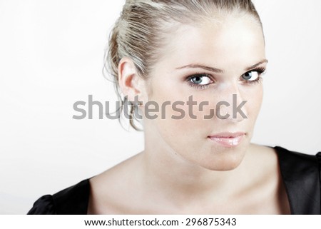 Head and Shoulder Shot of a Gorgeous Young Blond Woman Looking Fierce at the Camera Against White Background.