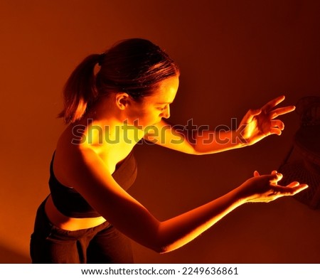 Close up side view profile portrait of one young middle age athletic woman shadow boxing in sportswear in gym over dark background, looking away