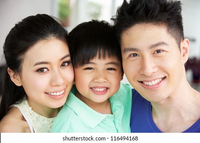 Head And Shoulders Portrait Of Chinese Family Together At Home