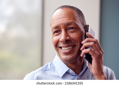 Head And Shoulders Portrait Of Mature Man Or Businessman Making Phone Call In Office Or At Home