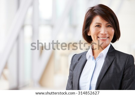 Head and shoulders portrait of smiling Asian businesswoman