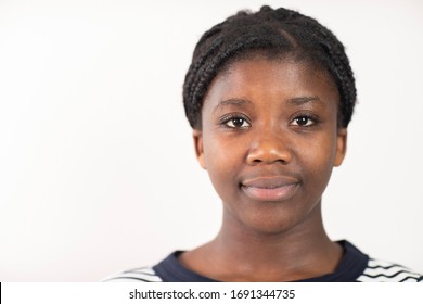 Head And Shoulders Studio Portrait Of Smiling Teenage Girl Against White Background