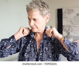 Head And Shoulders View Of Older Woman Adjusting Collar While Getting Dressed In Bedroom (selective Focus)