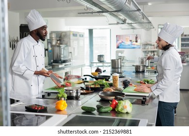 Head and sous chef discussing about what recipe to prepare for dinner service at fine dining restaurant. Skilled gastronomy experts cooking gourmet dish while in professional kitchen. - Powered by Shutterstock