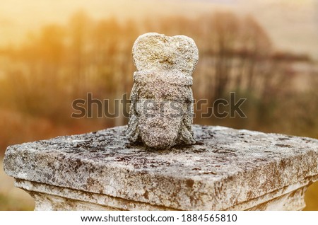 head of the statue is broken off from the torso on pedestal in old cemetery