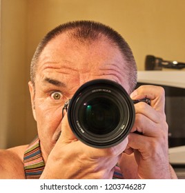 Head and two hands with a camera, middle-aged European