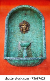 A Head Water Fountain On Red Wall