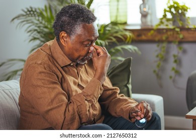 A Headache. Elderly African-American Who Suffers From Migraines And Sits At Home. Stressful Older Man Sitting In Bed At Home Alone, Touching His Head. Health Care, Health Problems In Old Age Concept.