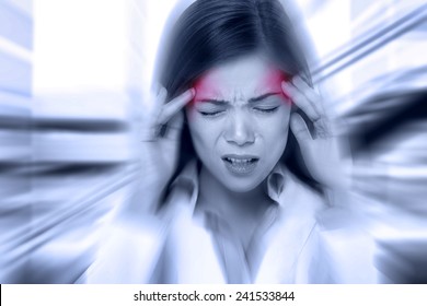 Headache migraine people - Doctor woman stressed. Woman Nurse / doctor with migraine headache overworked and stressed. Health care professional in lab coat wearing stethoscope at hospital. - Powered by Shutterstock