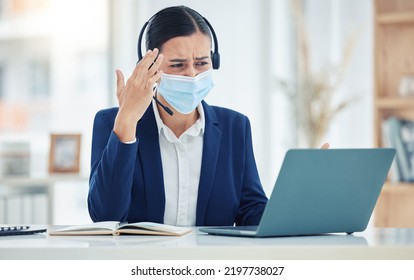 Headache, Pain And Tired Call Center Agent Working On A Laptop With Headset While Wearing Face Mask. Stressed, Burnout And Frustrated Customer Service Woman Working On Computer In A Corporate Office