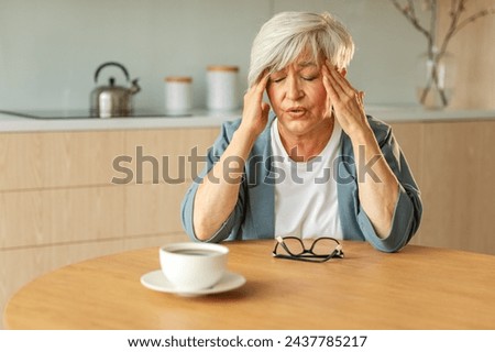 Headache pain. Unhappy middle aged senior woman suffering from headache sick rubbing temples at home. Mature old senior grandmother touching temples experiencing stress Woman feeling pain hurt in head
