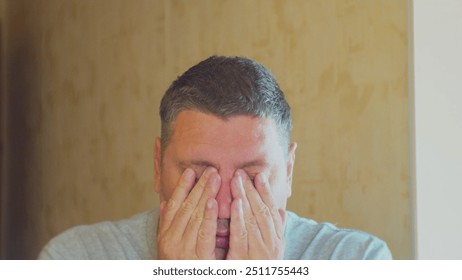 Headache. Stress and emotional load of modern man. Middle-aged man struggling with stress. Close-up portrait.
